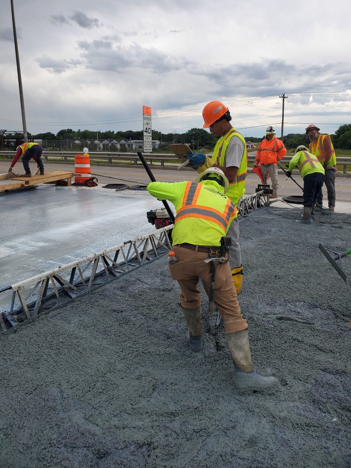 Crew placing and finishing concrete overlay